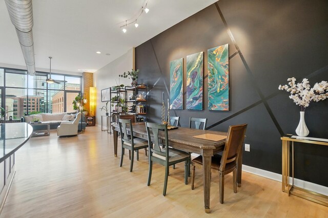 300 W Spring St Unit 515, Columbus, OH 43215 - dining room with light wood-style floors, baseboards, expansive windows, and a ceiling fan