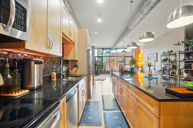 300 W Spring St Unit 515, Columbus, OH 43215 - kitchen featuring stainless steel appliances, a sink, backsplash, recessed lighting, and dark stone countertops