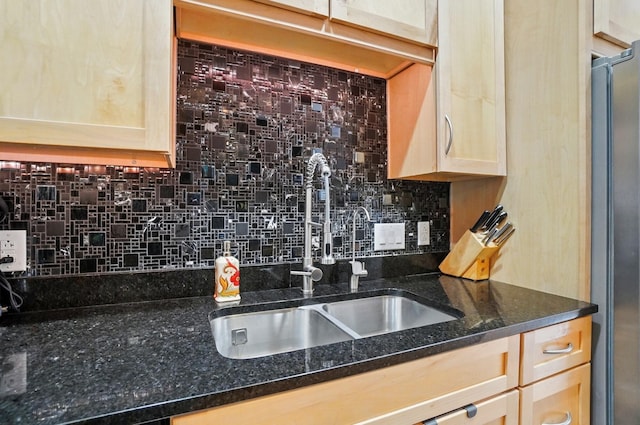 300 W Spring St Unit 515, Columbus, OH 43215 - kitchen featuring a sink, stainless steel fridge, decorative backsplash, and dark stone counters