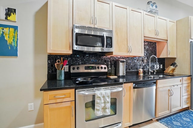 300 W Spring St Unit 515, Columbus, OH 43215 - kitchen with stainless steel appliances, a sink, tasteful backsplash, and dark stone countertops