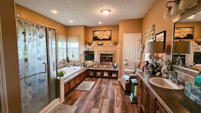 5353 Buckeye Valley Rd NE, New Lexington, OH 43764 - full bath with a tiled fireplace, a shower stall, a textured ceiling, a garden tub, and vanity