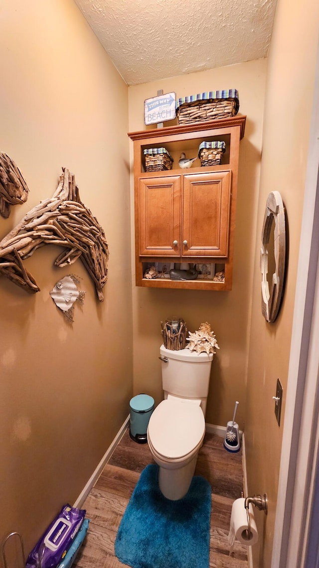 5353 Buckeye Valley Rd NE, New Lexington, OH 43764 - bathroom with toilet, a textured ceiling, wood finished floors, and baseboards