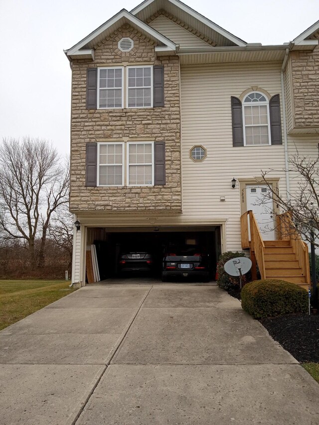 5888 Abernathy Ln Unit 5888A, Columbus, OH 43232 - view of front of property featuring an attached garage, stone siding, and concrete driveway