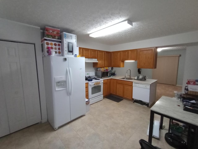 5888 Abernathy Ln Unit 5888A, Columbus, OH 43232 - kitchen featuring white appliances, under cabinet range hood, a sink, light countertops, and a textured ceiling