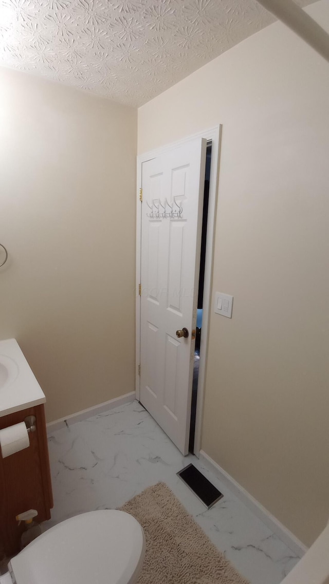5888 Abernathy Ln Unit 5888A, Columbus, OH 43232 - bathroom featuring marble finish flooring, vanity, baseboards, and a textured ceiling