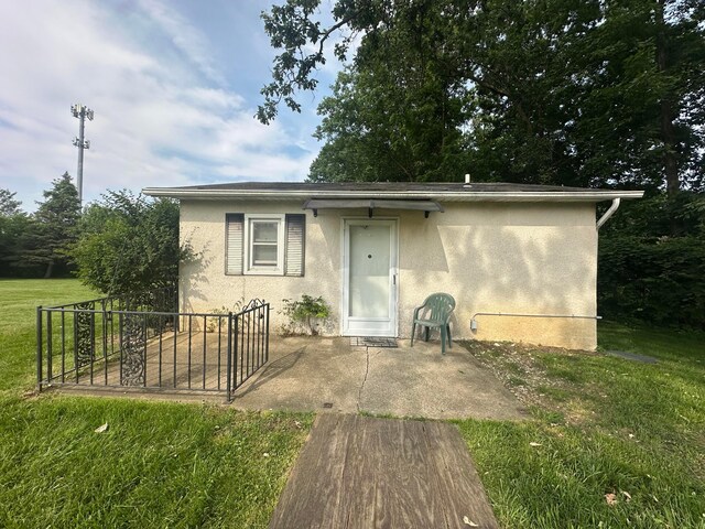 3303 Lowell Dr, Columbus, OH 43204 - view of front of property with stucco siding, a patio area, and a front yard