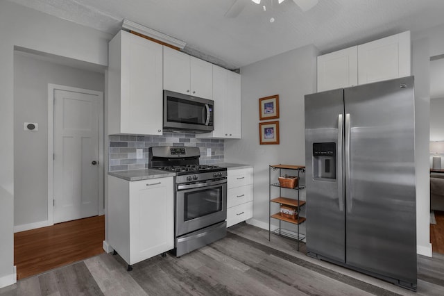 6641 Charles Rd, Westerville, OH 43082 - kitchen featuring appliances with stainless steel finishes, dark wood-style flooring, a ceiling fan, and white cabinets
