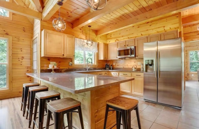 820 Pump Station Rd SE, Sugar Grove, OH 43155 - kitchen with appliances with stainless steel finishes, wooden walls, beam ceiling, light brown cabinetry, and a breakfast bar area