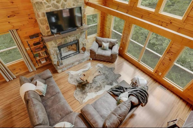 820 Pump Station Rd SE, Sugar Grove, OH 43155 - living room featuring plenty of natural light, wood finished floors, a stone fireplace, and wooden walls