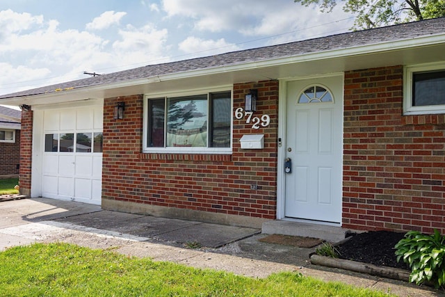 6729 Retton Rd, Reynoldsburg, OH 43068 - view of exterior entry featuring brick siding, driveway, and a garage