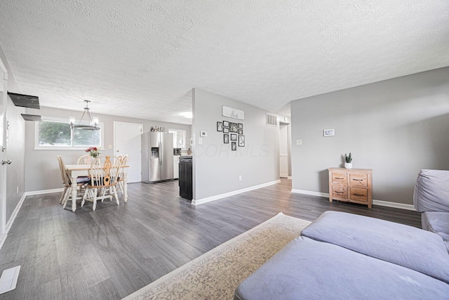 6729 Retton Rd, Reynoldsburg, OH 43068 - living room with a textured ceiling, dark wood-style floors, baseboards, and a chandelier
