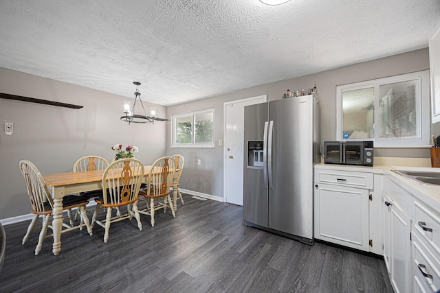 6729 Retton Rd, Reynoldsburg, OH 43068 - dining area with dark wood-type flooring, a textured ceiling, baseboards, and a chandelier