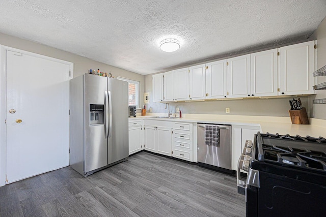 6729 Retton Rd, Reynoldsburg, OH 43068 - kitchen featuring stainless steel appliances, a sink, dark wood-type flooring, light countertops, and white cabinetry