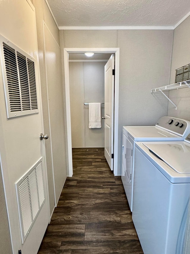 clothes washing area featuring dark wood-style floors, separate washer and dryer, crown molding, and a textured ceiling