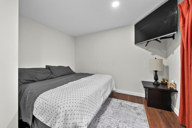 bedroom with wood finished floors and baseboards