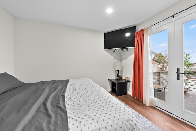 bedroom featuring wood finished floors, access to exterior, and recessed lighting