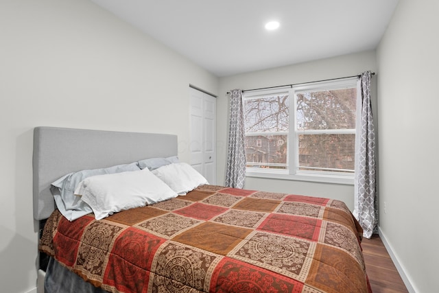 bedroom featuring wood finished floors, baseboards, recessed lighting, and a closet