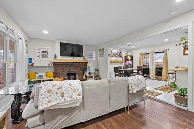 living area with a brick fireplace, wood finished floors, and recessed lighting