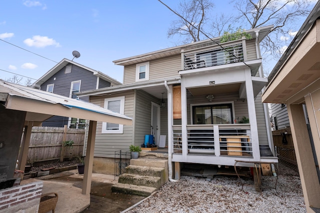 view of front of house featuring fence, a balcony, and a porch
