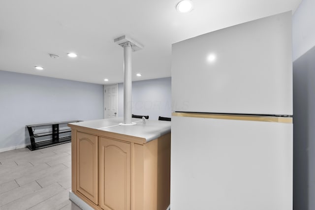 kitchen with freestanding refrigerator, recessed lighting, light brown cabinets, and light countertops