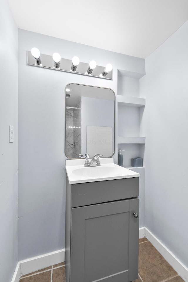 bathroom featuring vanity, baseboards, and tile patterned floors