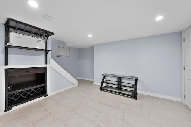 finished below grade area featuring recessed lighting, baseboards, and tile patterned floors