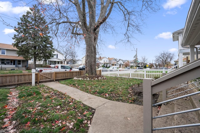 fenced backyard featuring a residential view and a gate