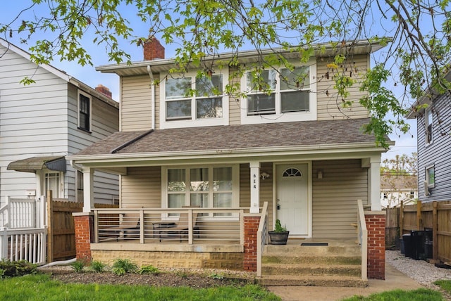 view of front of property featuring a porch, fence, and a chimney