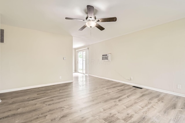 unfurnished room featuring a ceiling fan, wood finished floors, a wall mounted air conditioner, and baseboards