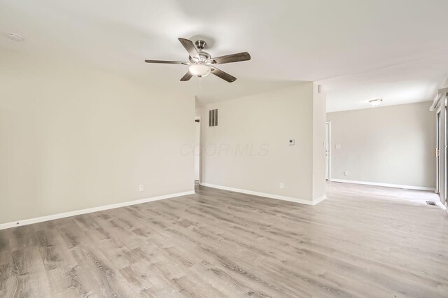 empty room with ceiling fan, light wood-type flooring, baseboards, and a smoke detector