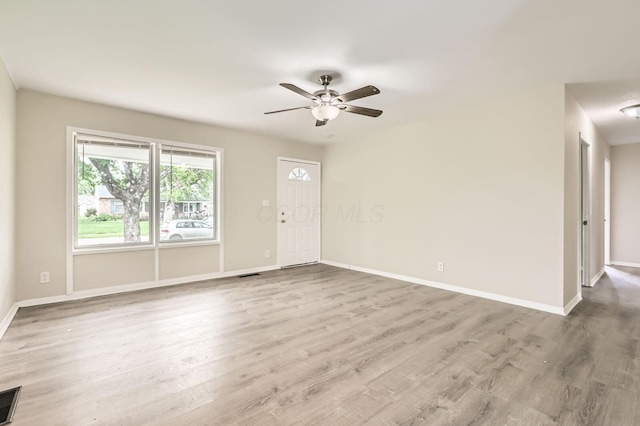 unfurnished living room featuring baseboards, a ceiling fan, and wood finished floors