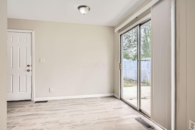 spare room with light wood-style flooring and baseboards