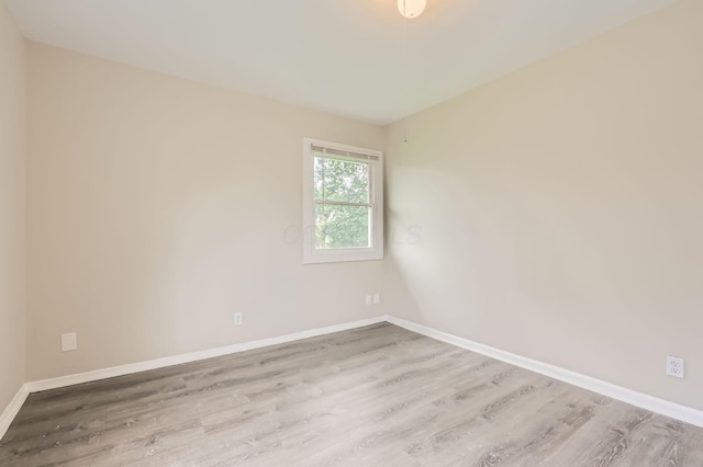 empty room featuring wood finished floors and baseboards
