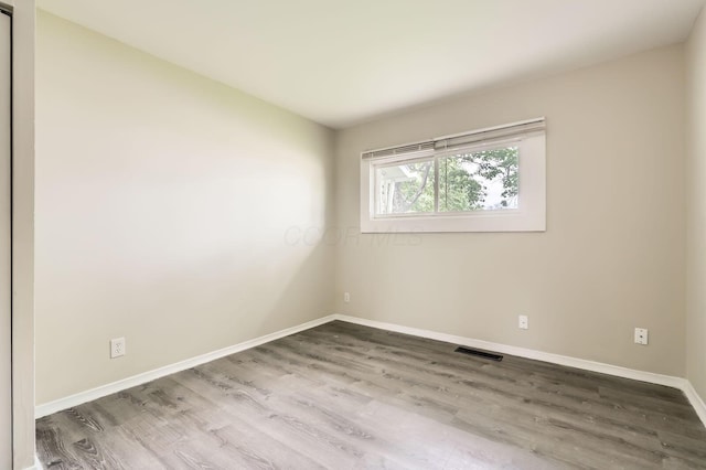 spare room featuring wood finished floors and baseboards