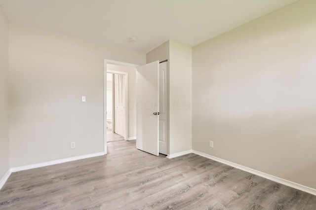 spare room featuring baseboards and wood finished floors