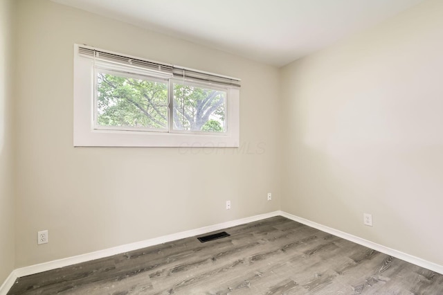 spare room featuring wood finished floors and baseboards