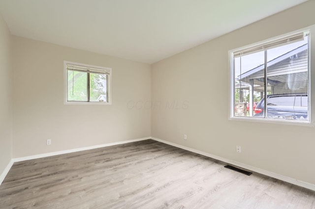 empty room featuring wood finished floors and baseboards