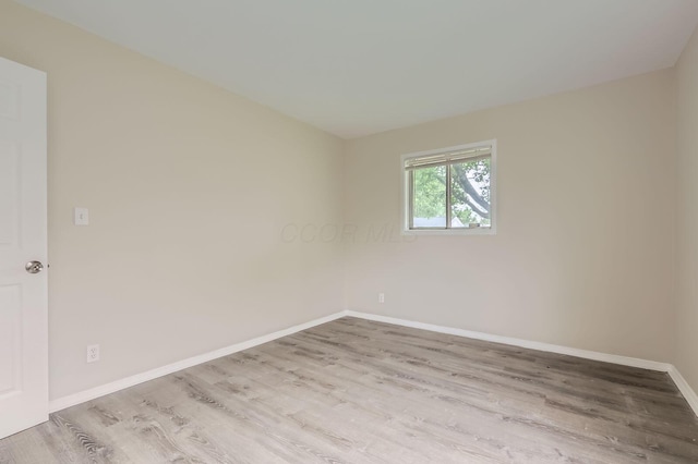 spare room featuring wood finished floors and baseboards