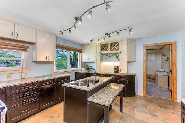 200 Park Ave, New Lexington, OH 43764 - kitchen featuring a sink, light stone countertops, dark brown cabinets, and a kitchen island with sink