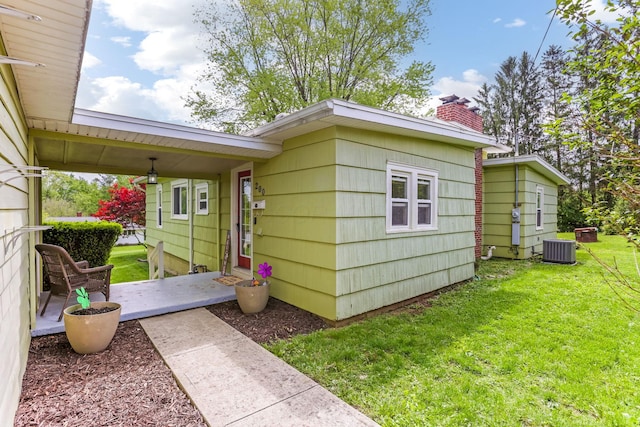 200 Park Ave, New Lexington, OH 43764 - view of property exterior featuring a lawn, a chimney, and central AC