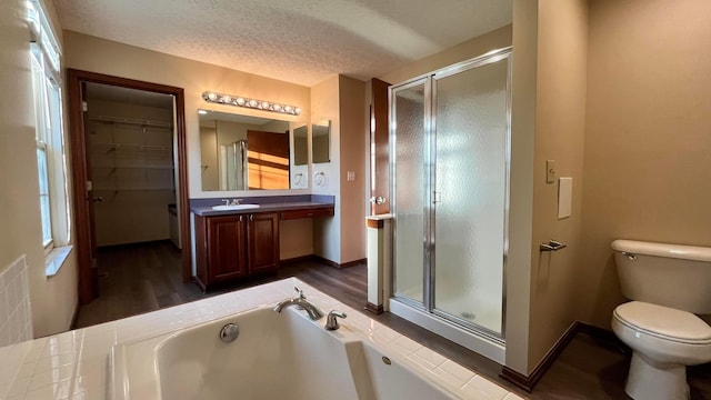 7586 Jenkins Dr, Canal Winchester, OH 43110 - bathroom featuring a shower stall, a bath, toilet, wood finished floors, and a textured ceiling