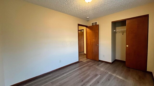 7586 Jenkins Dr, Canal Winchester, OH 43110 - unfurnished bedroom featuring wood finished floors, a textured ceiling, a closet, and baseboards