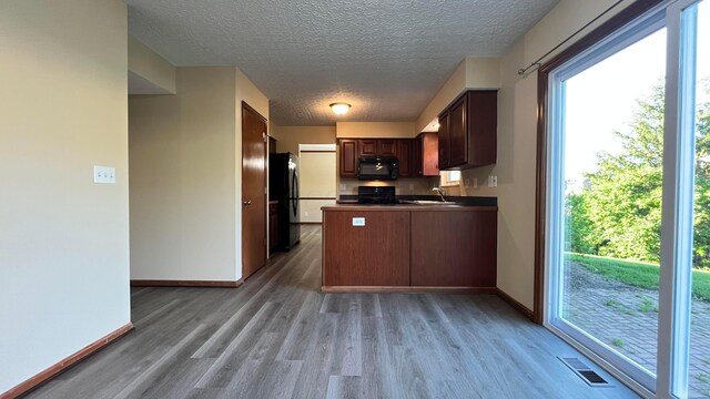 7586 Jenkins Dr, Canal Winchester, OH 43110 - kitchen with black appliances, light wood-type flooring, a sink, baseboards, and a textured ceiling