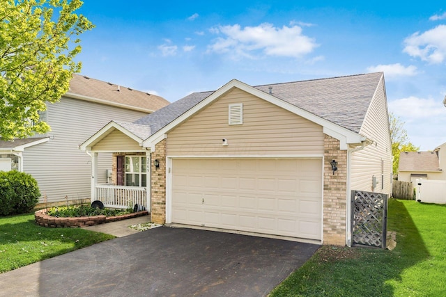 traditional home with brick siding, asphalt driveway, an attached garage, and a shingled roof