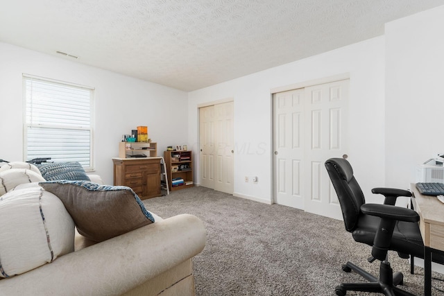 office with carpet flooring and a textured ceiling