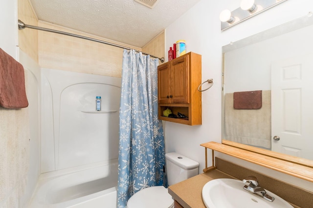 bathroom with toilet, shower / tub combo with curtain, vanity, and a textured ceiling