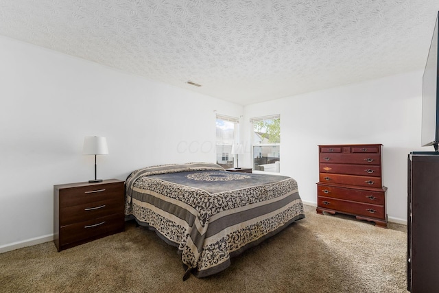 bedroom featuring a textured ceiling, carpet floors, and baseboards