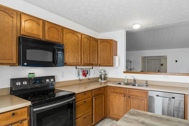 kitchen with black appliances, a sink, light countertops, brown cabinets, and a textured ceiling
