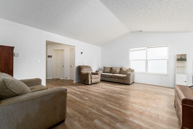 living room with lofted ceiling, wood-type flooring, a textured ceiling, and baseboards