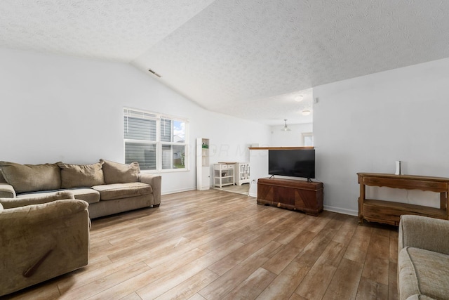 living room featuring light wood-style floors, a textured ceiling, vaulted ceiling, and baseboards